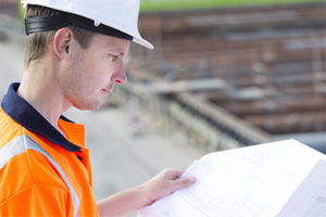 A RREM contractor reviews paperwork for a house raising project.